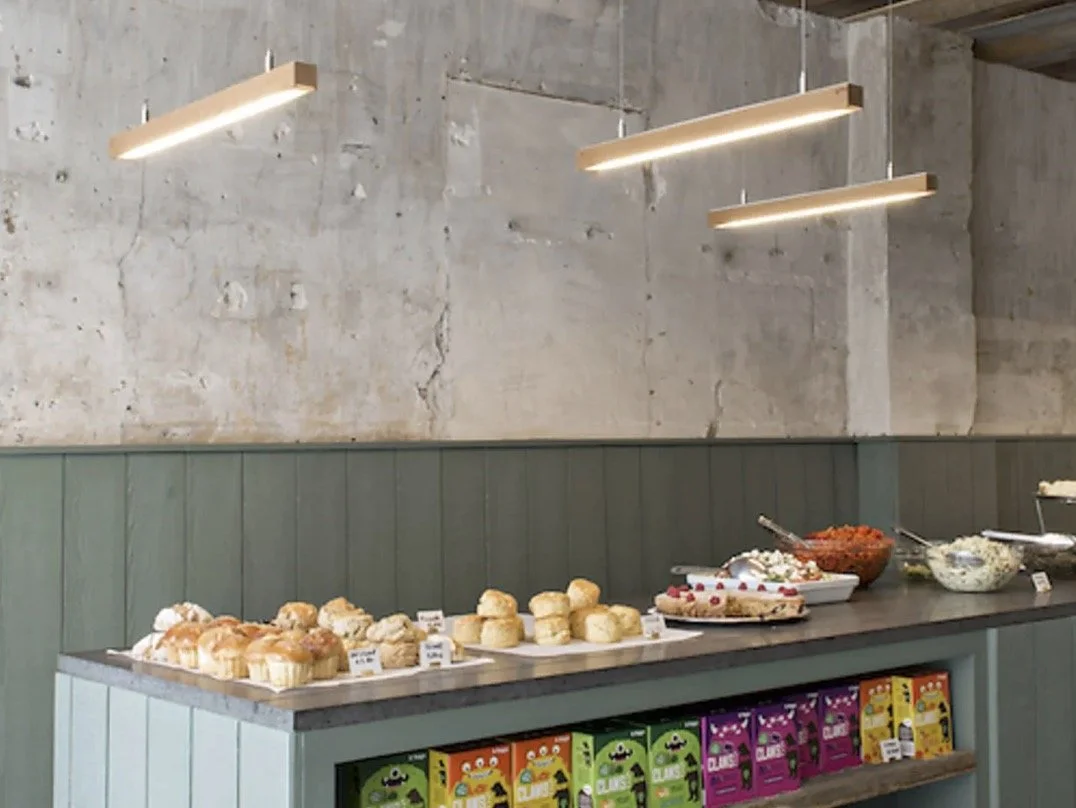 Buffet avec des plats et des desserts, incluant des petits sandwichs, des salades et des desserts, dans un décor industriel.