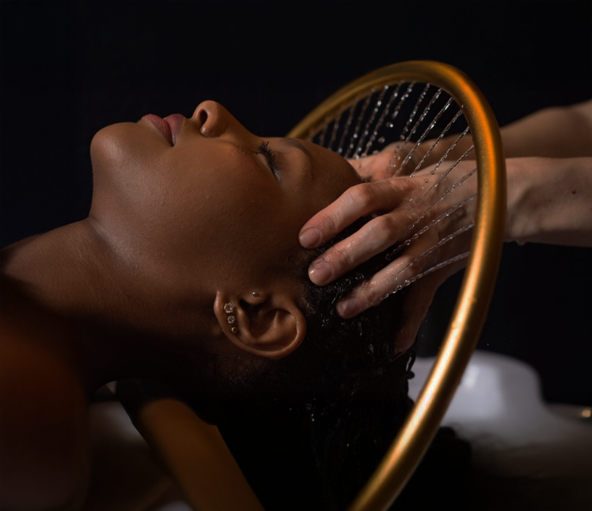 Une femme reçoit un soin head spa dans un environnement relaxant de spa.