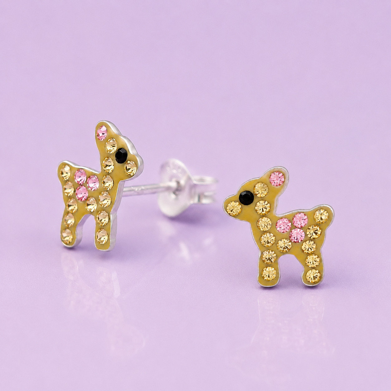 Pair of bunny-shaped stud earrings decorated with pink, yellow, and black rhinestones on a purple background.