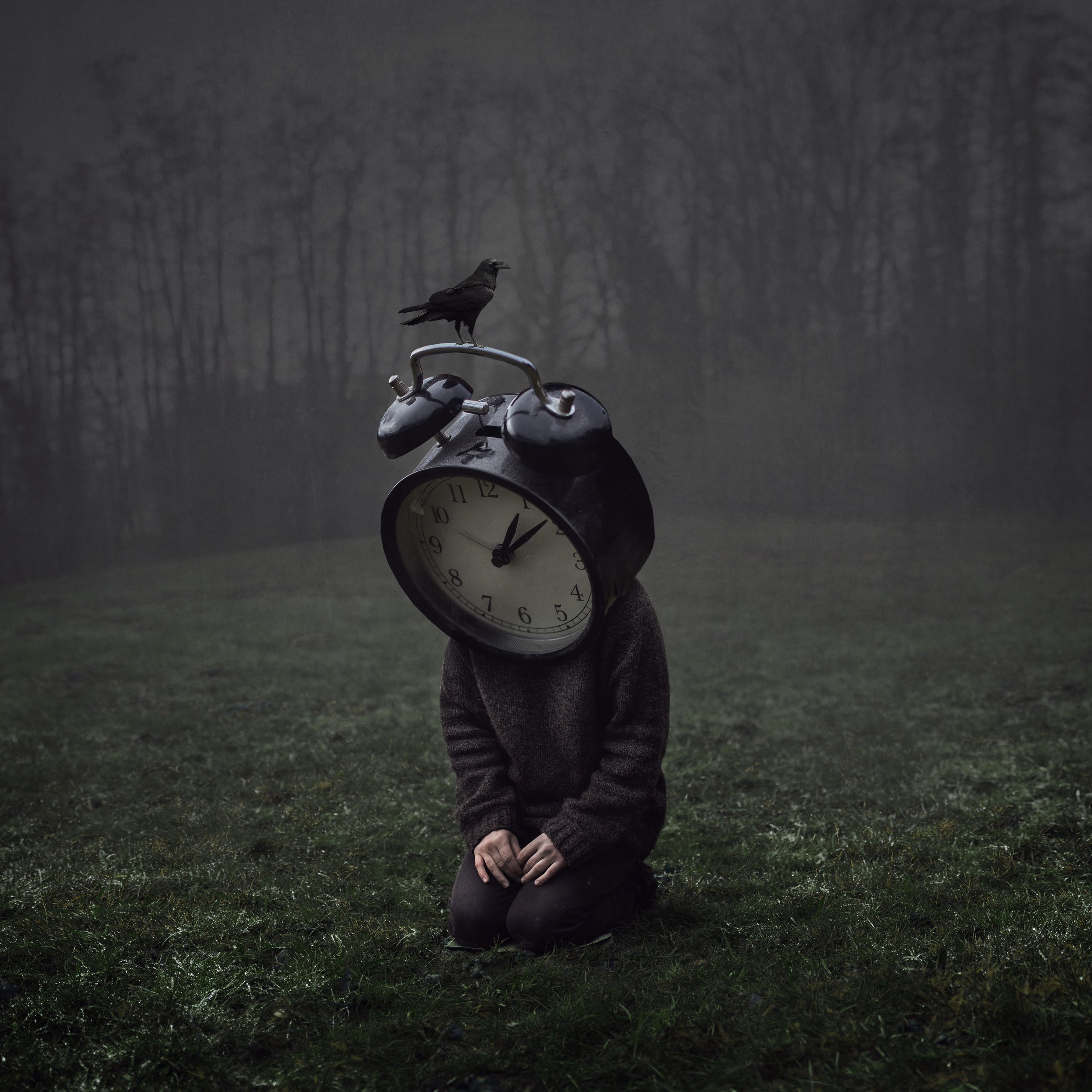Eine Person im Sitzen auf dem Boden in einem nebligen Wald mit einem Wecker-Kopf und einer Krähe auf dem Weckturm