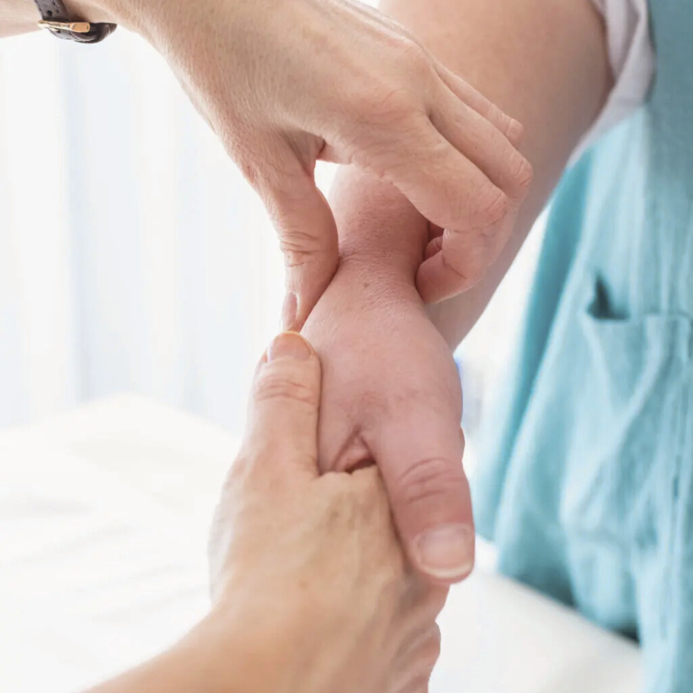 A healthcare professional examining a patient's wrist for signs of pain or injury.
