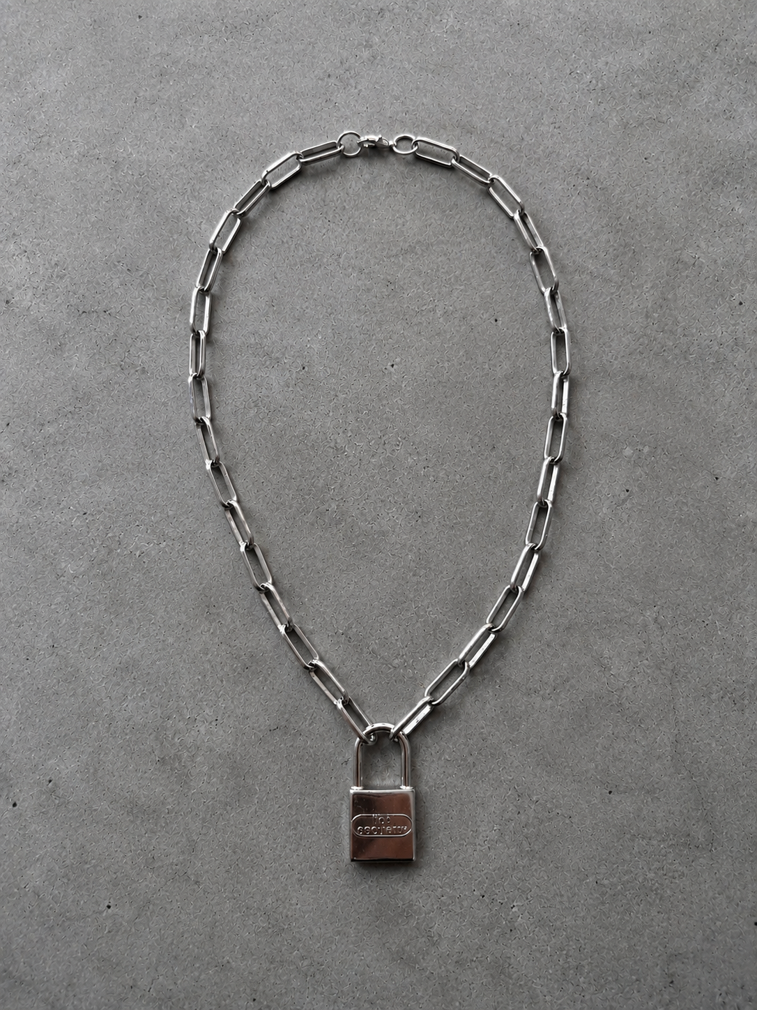 Stainless steel chain necklace with a padlock pendant.