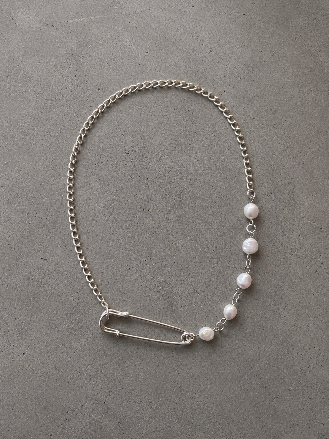Stainless steel chain necklace with natural freshwater pearls and a safety pin clasp.