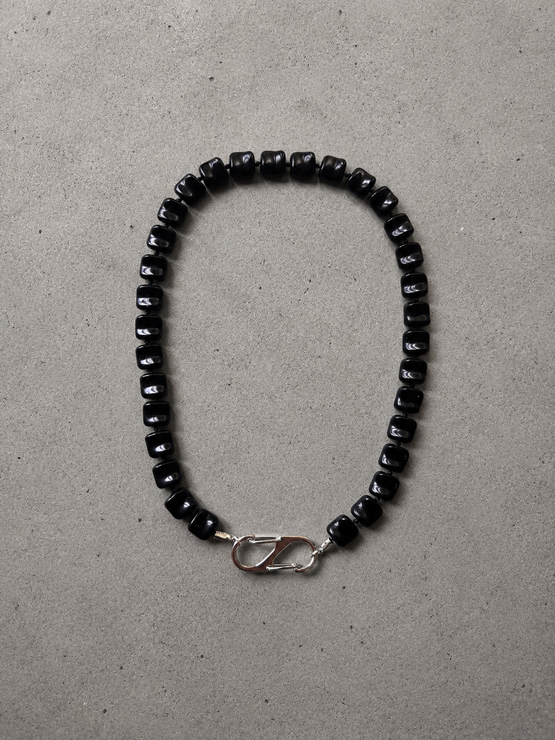Black acrylic stone necklace with a stainless steel carabiner clasp.