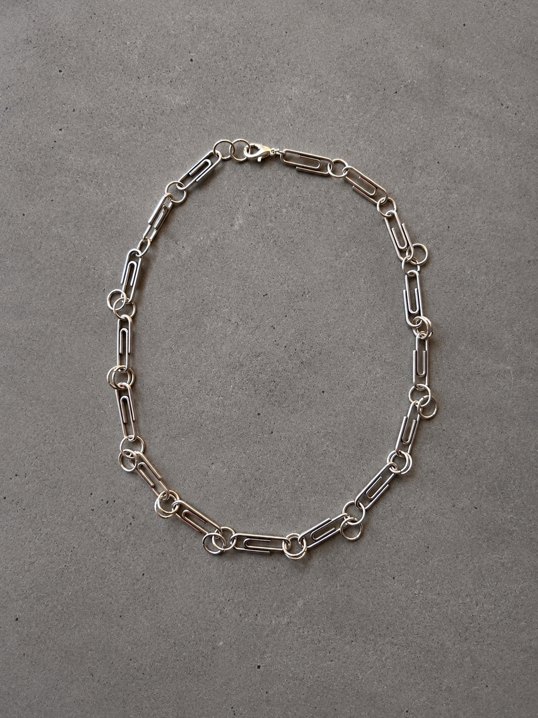 Stainless steel ring necklace with clip-style charms.