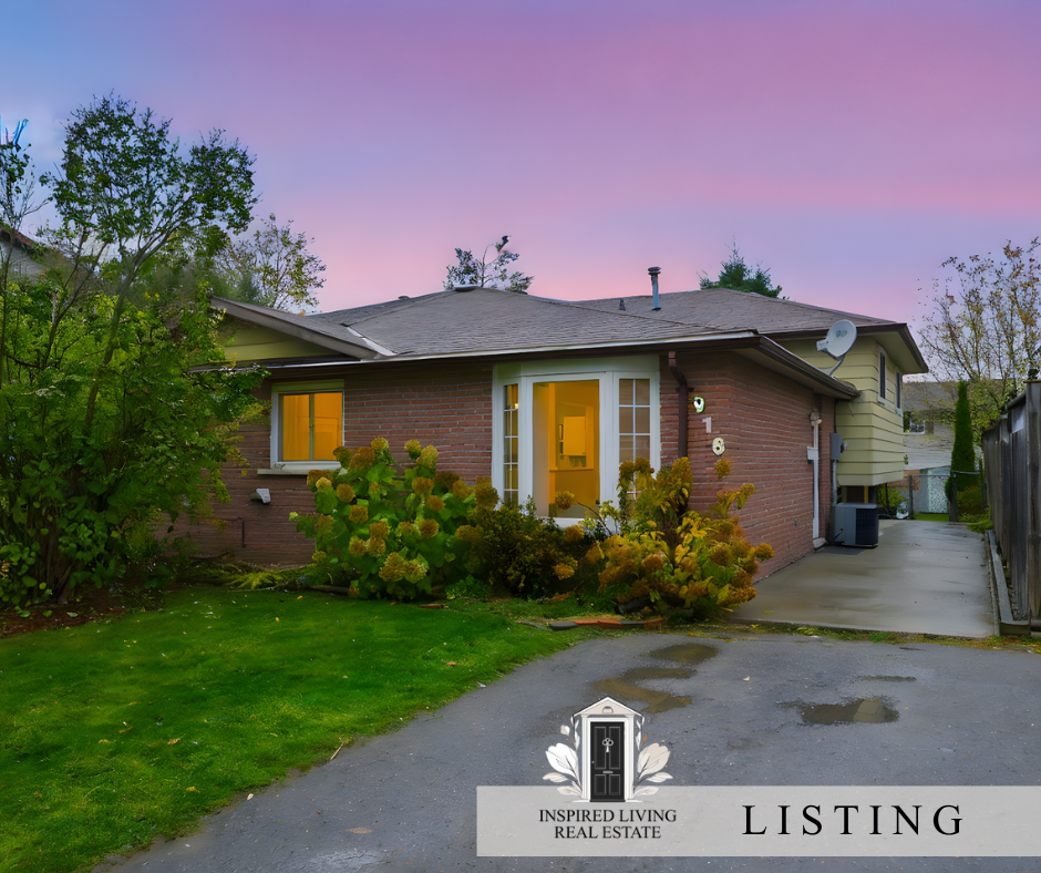 Exterior view of a single-story house with brick facade and yellow siding, surrounded by greenery, with a driveway and a purple sky at sunset.