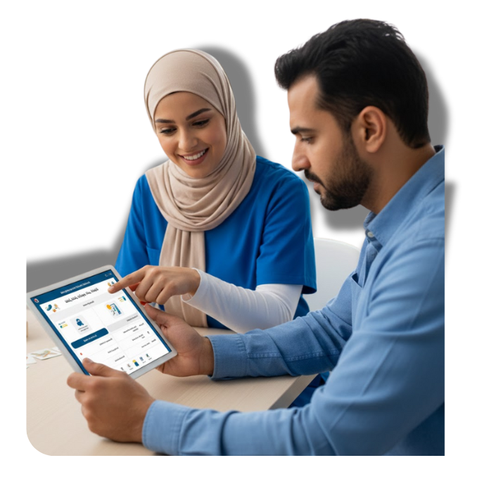 A woman in a beige hijab and blue shirt smiling while using a tablet, sitting next to a man in a blue shirt who is also using the tablet, both focused on the device.