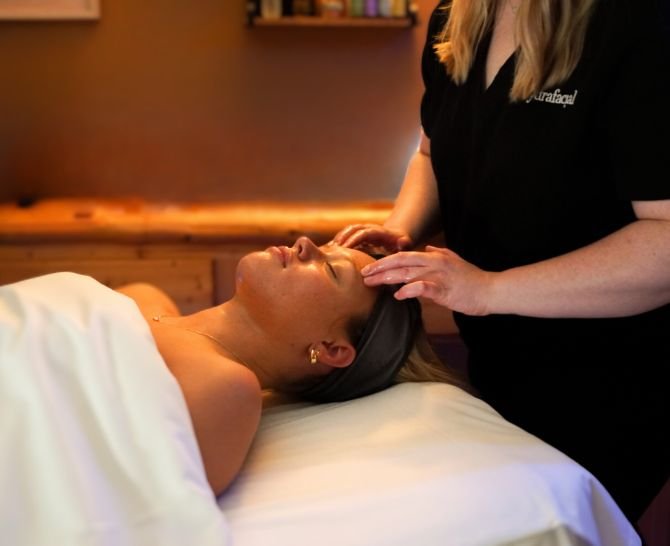 woman lying on back receiving facial at spa