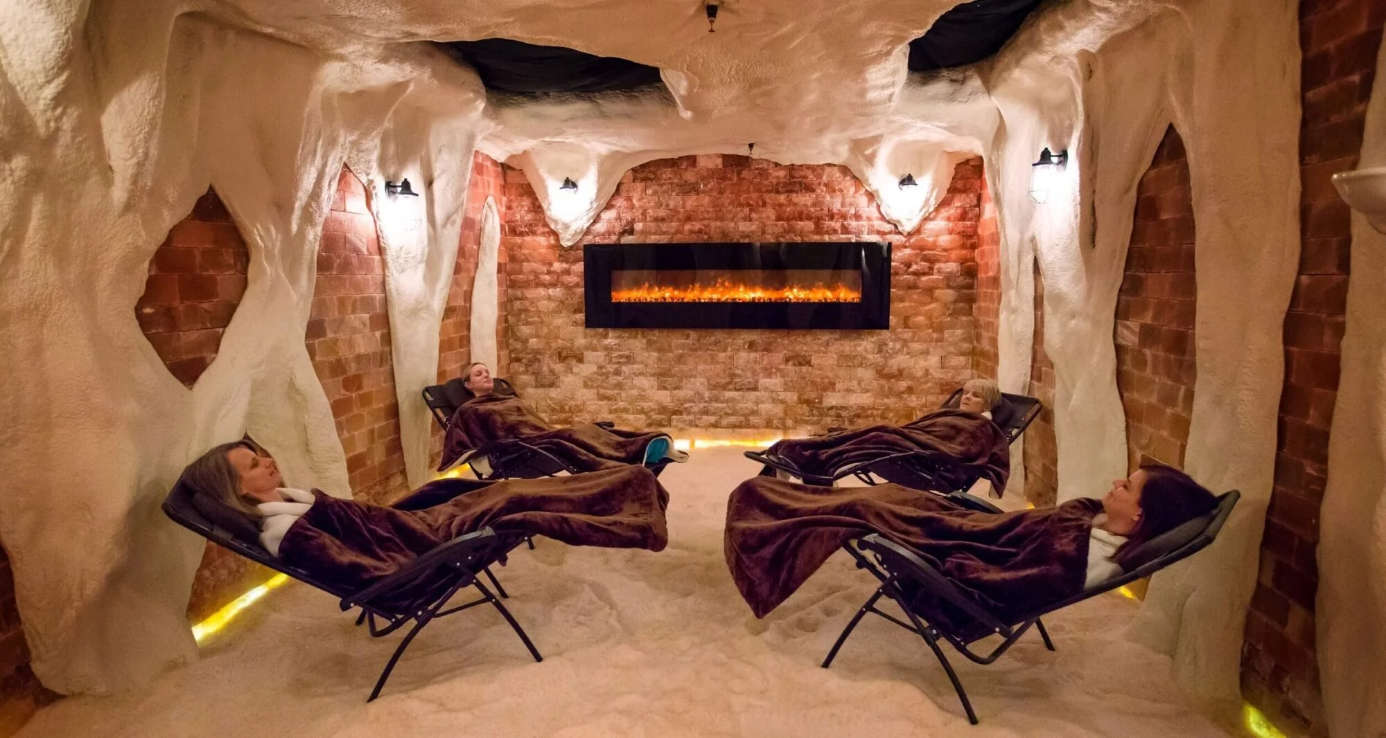 4 women reclined in chairs with blankets on in himalayan salt cave