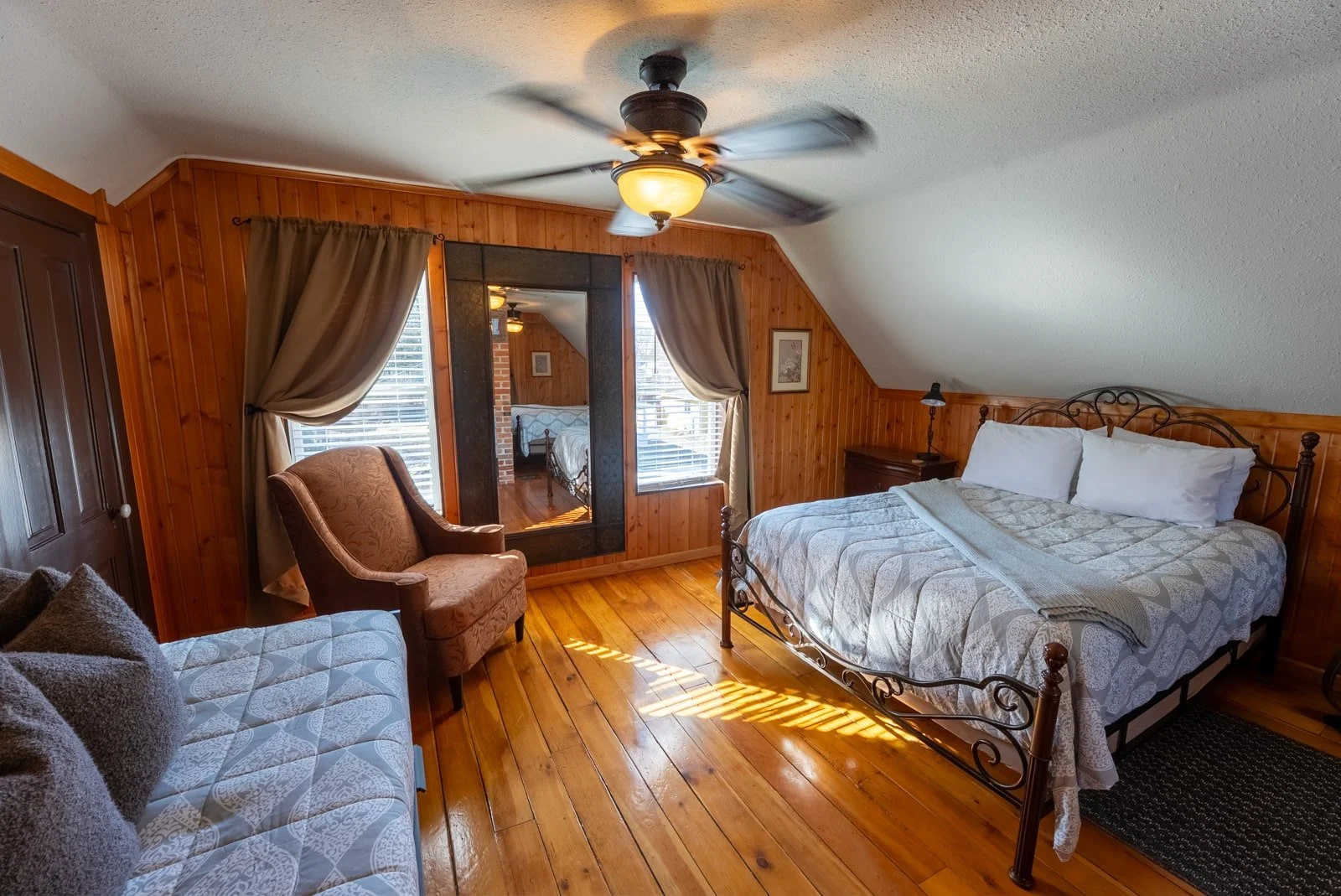 Bedroom with bed, daybed, and chair in The Log Cabin home