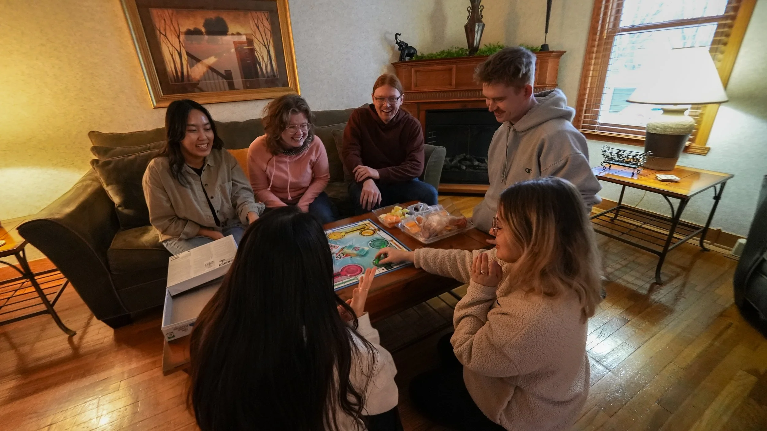 group of people playing board game at coffee table