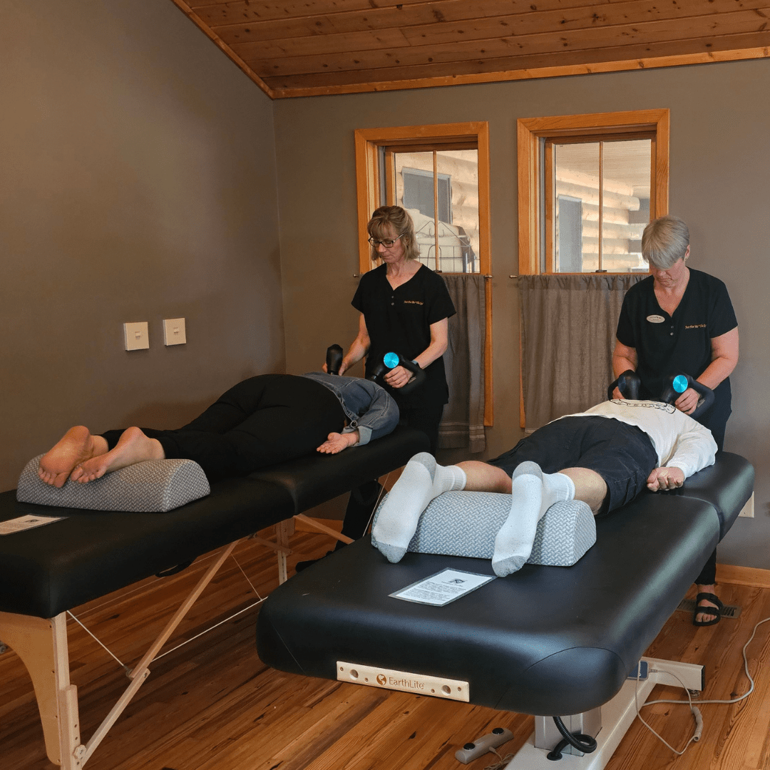 two individuals receiving Theragun percussion massage