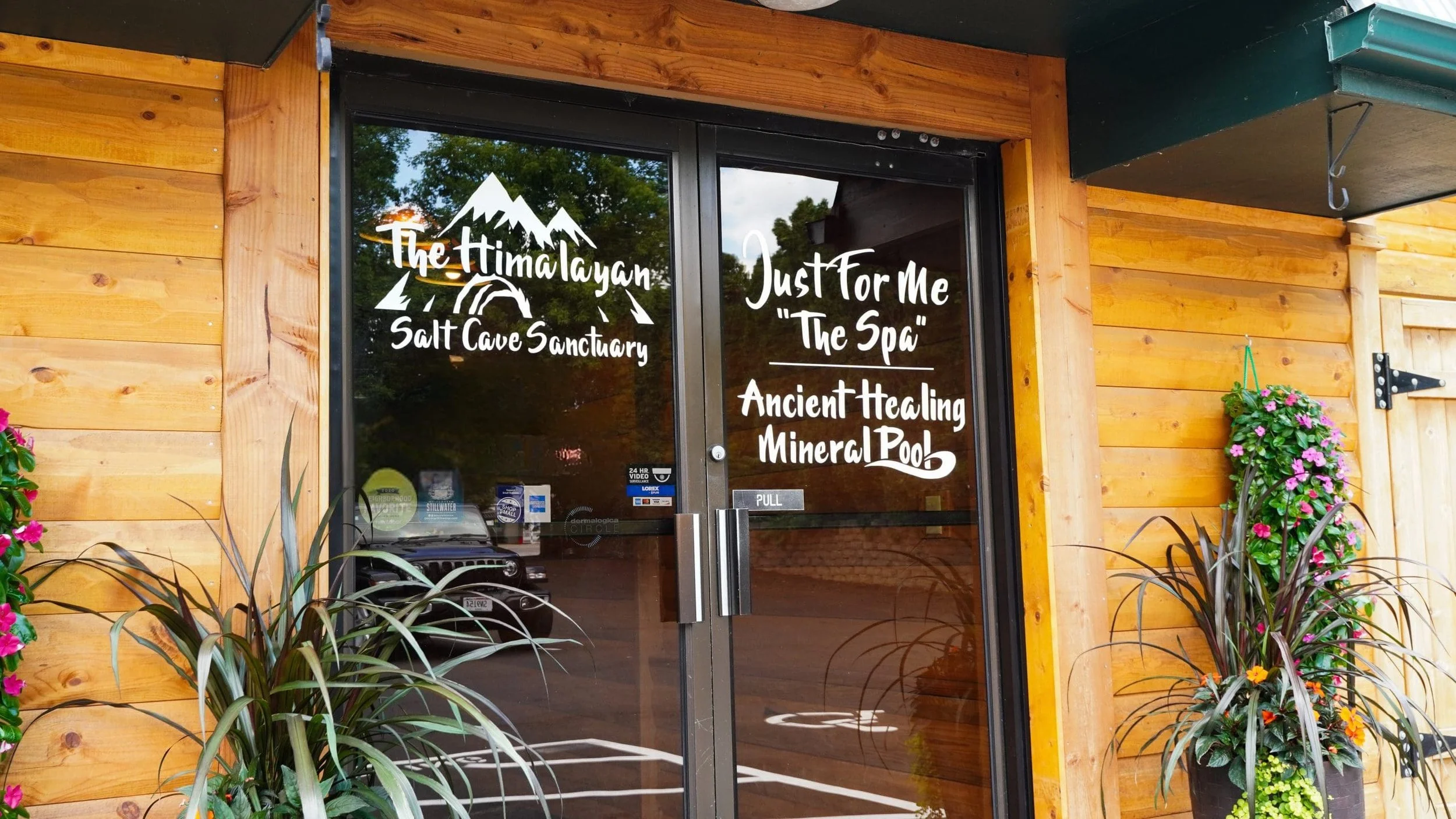 front doors of Just For Me Spa with logo and signs for salt cave and mineral pool