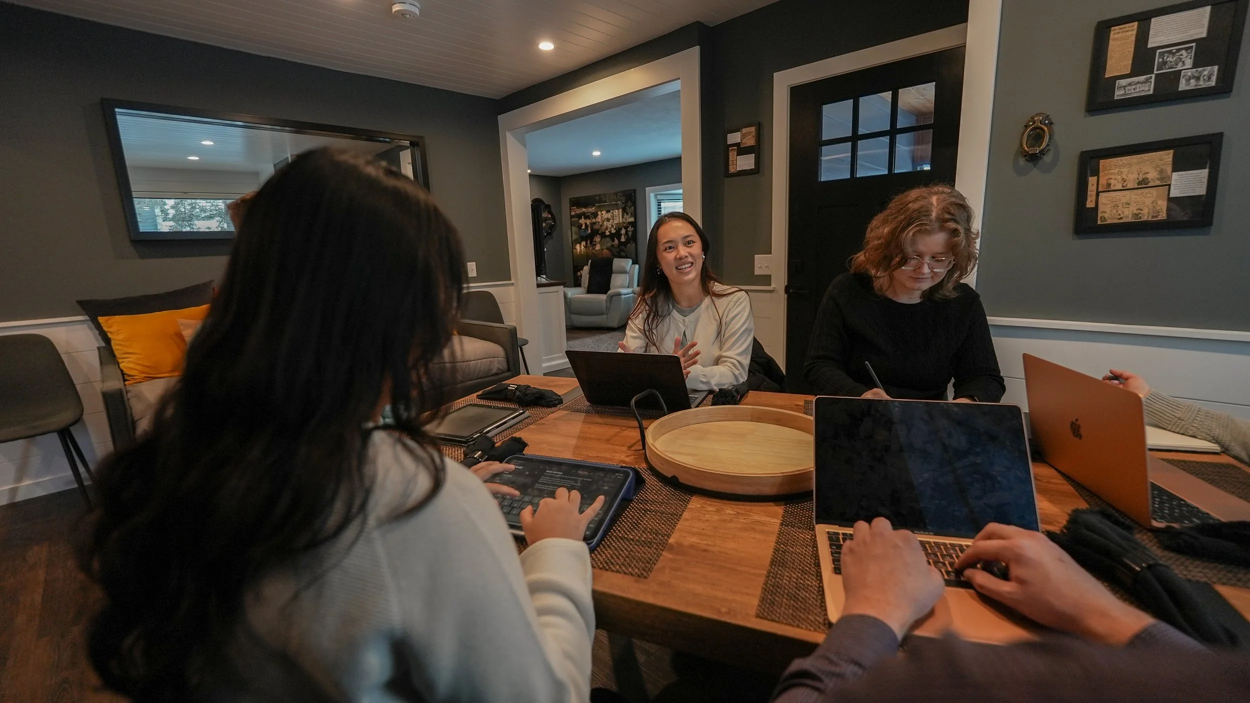 group of people working on laptops at dining table