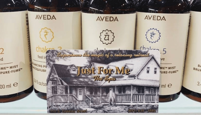Aveda hair products behind black and white picture of Just For Me Spa