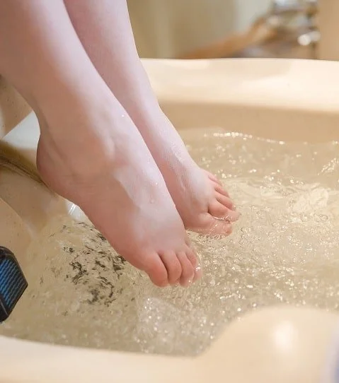 woman soaking feet during pedicure