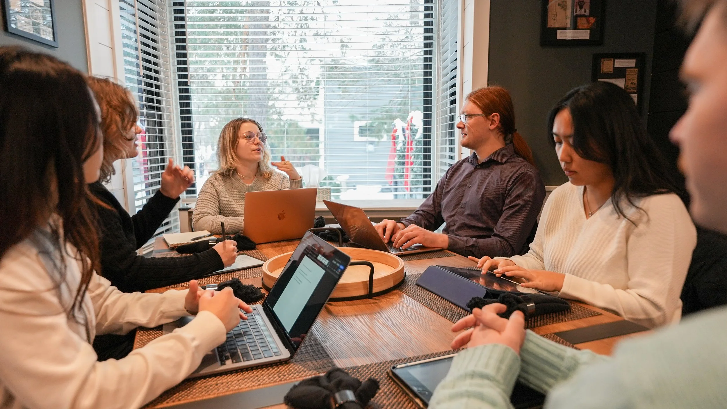 group of people working on laptops and iPads at table