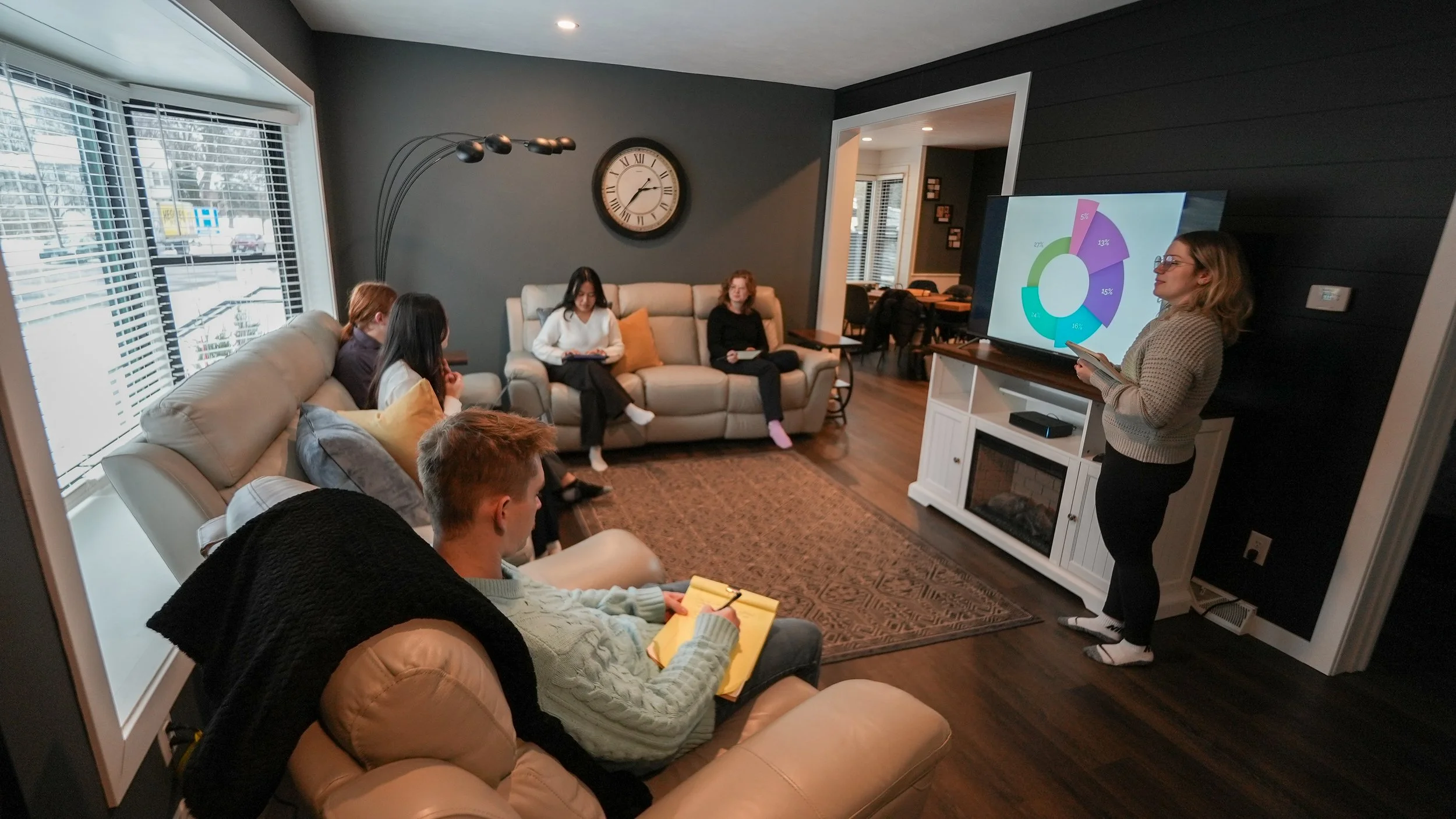 woman giving presentation to group of people in living room