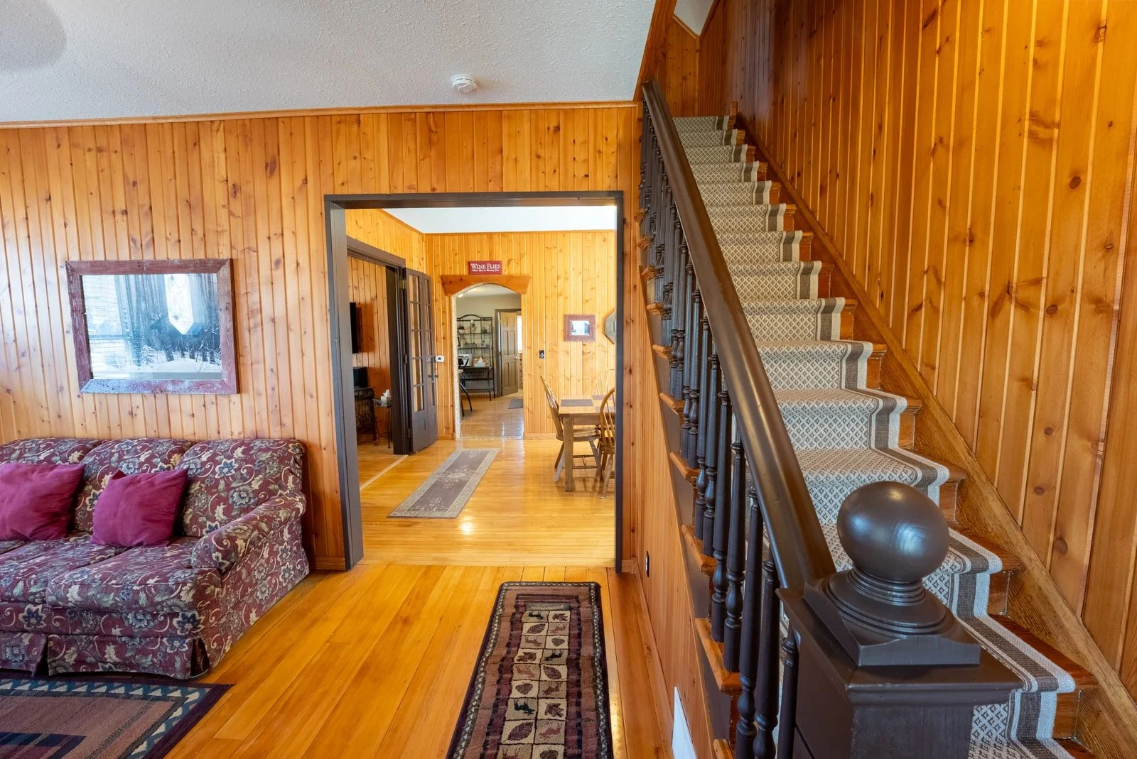 View of stairs and dining room entry in The Log Cabin home