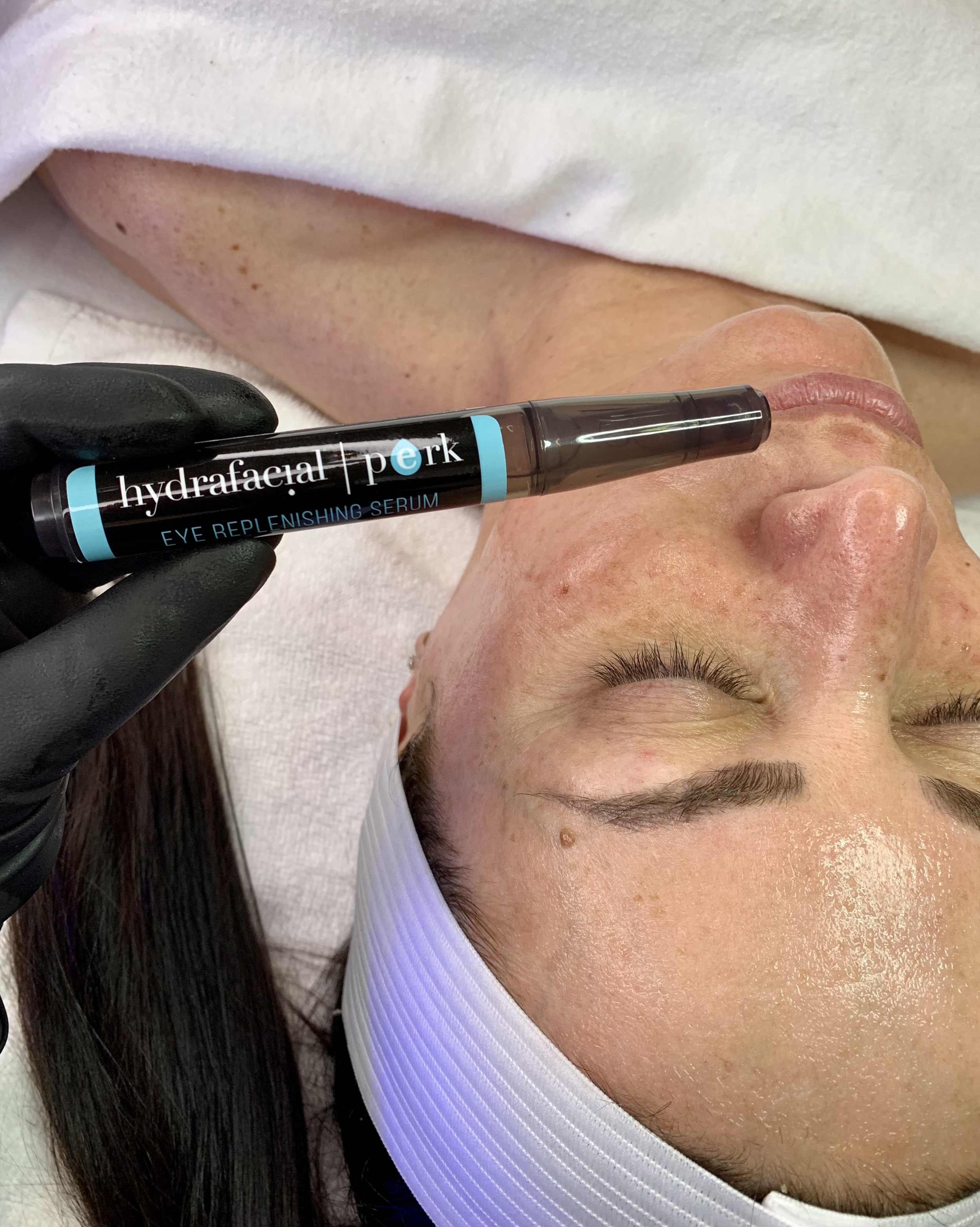 woman's face with eyes closed and hydrafacial eye replenishing serum