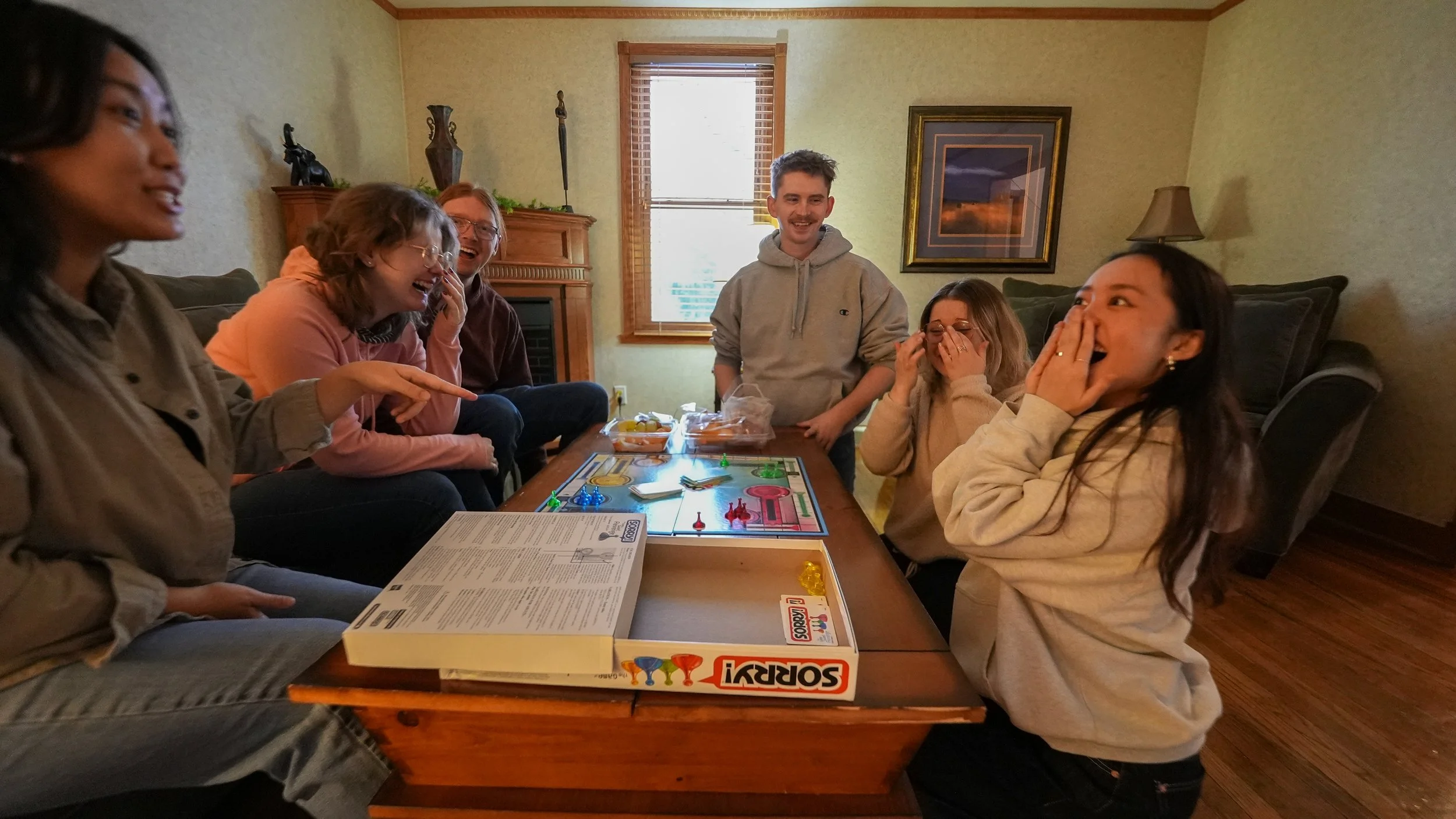 group of people having fun playing a board game at coffee table