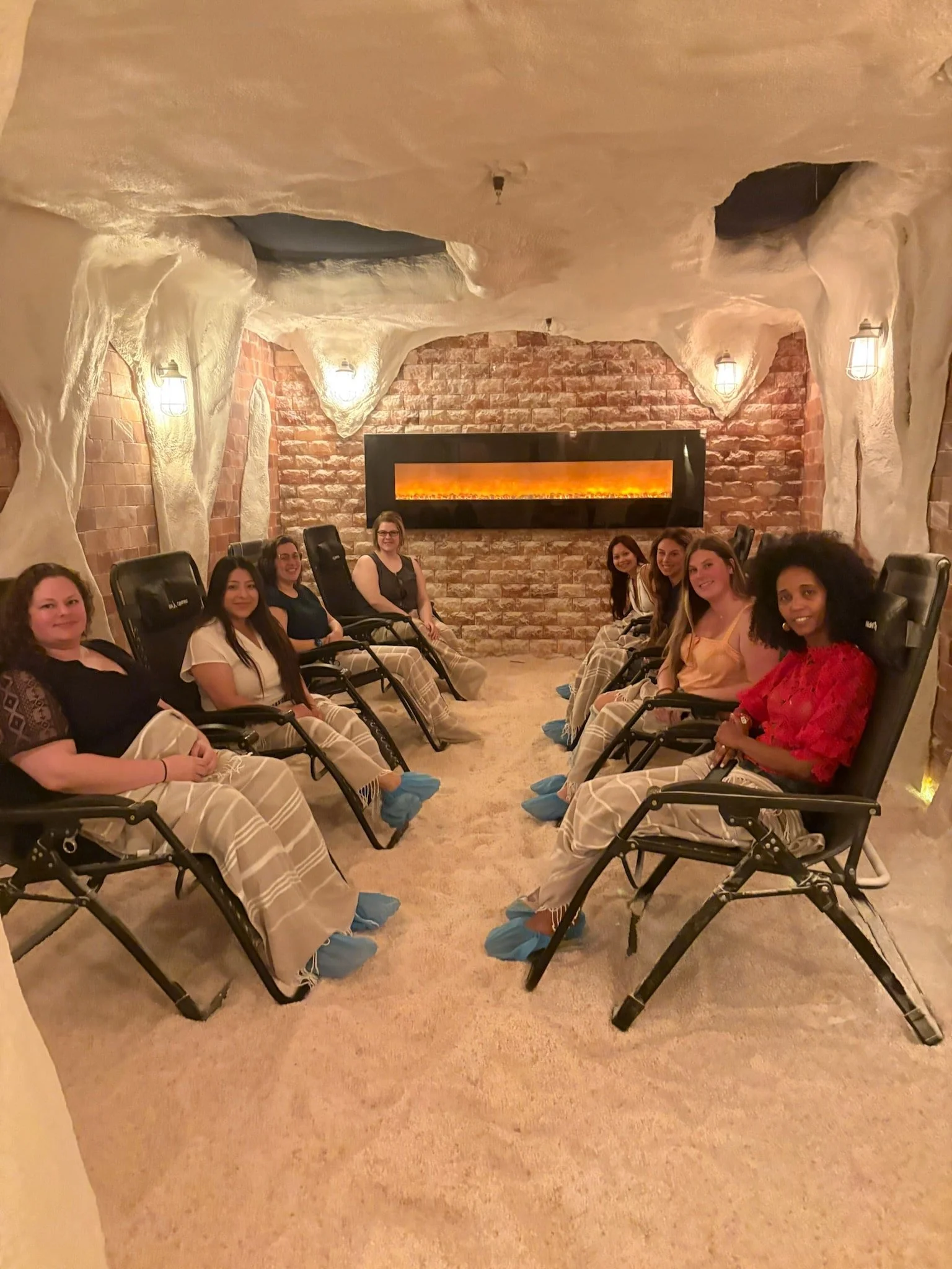 group of people sitting in chairs in salt cave and smiling