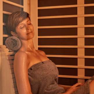 woman relaxing in sauna with towel rolled up behind neck