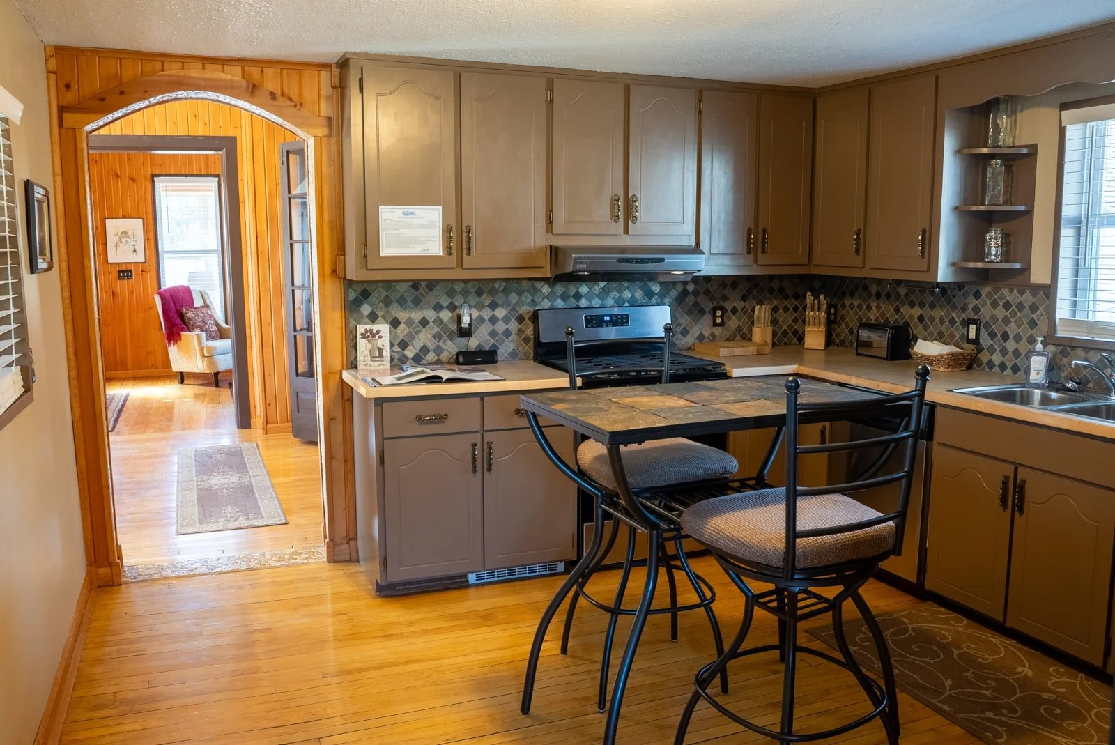 Kitchen with high-top table and two chairs in The Log Cabin home