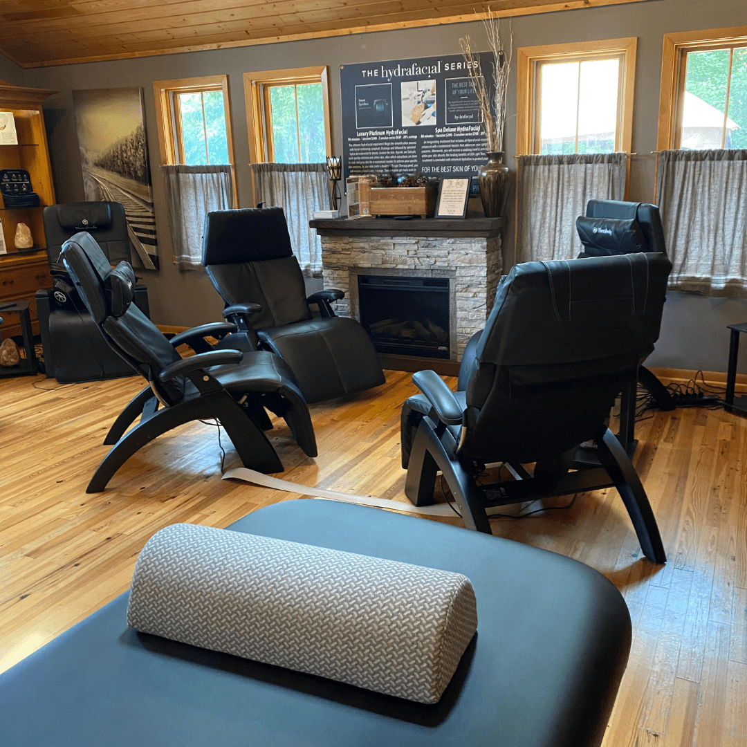 different angle of 4 black reclining chairs in circle in front of fireplace