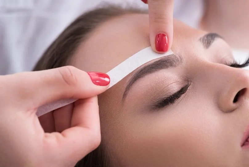 woman receiving eyebrow wax