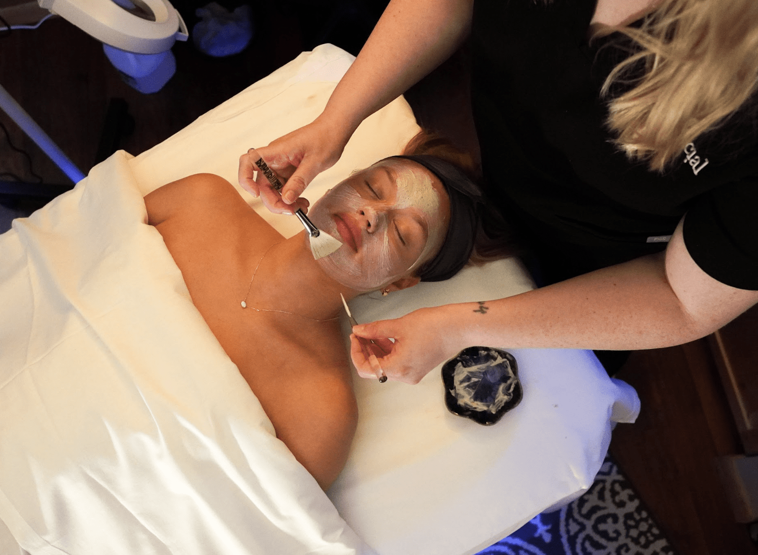 woman lying on back receiving facial