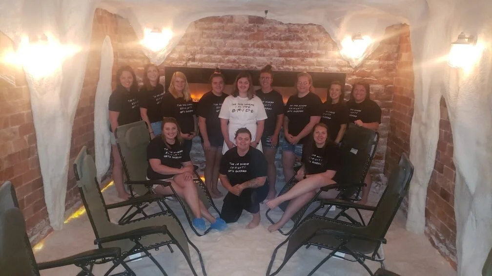group of women in t-shirts posing in salt cave