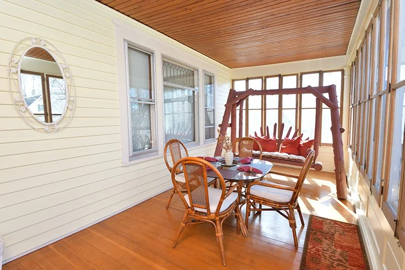 Porch with wooden swing and table and chairs