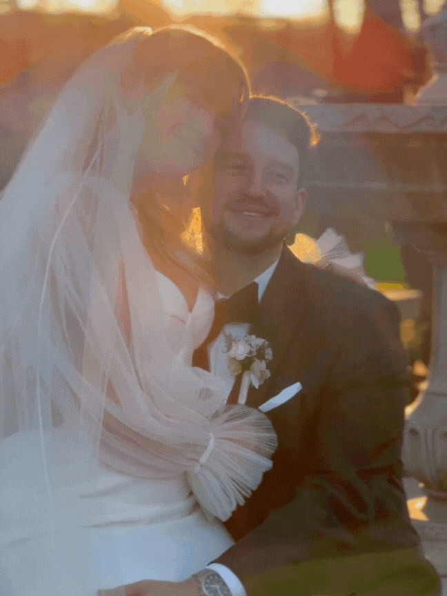 A bride and groom smiling together at sunset during their wedding celebration.