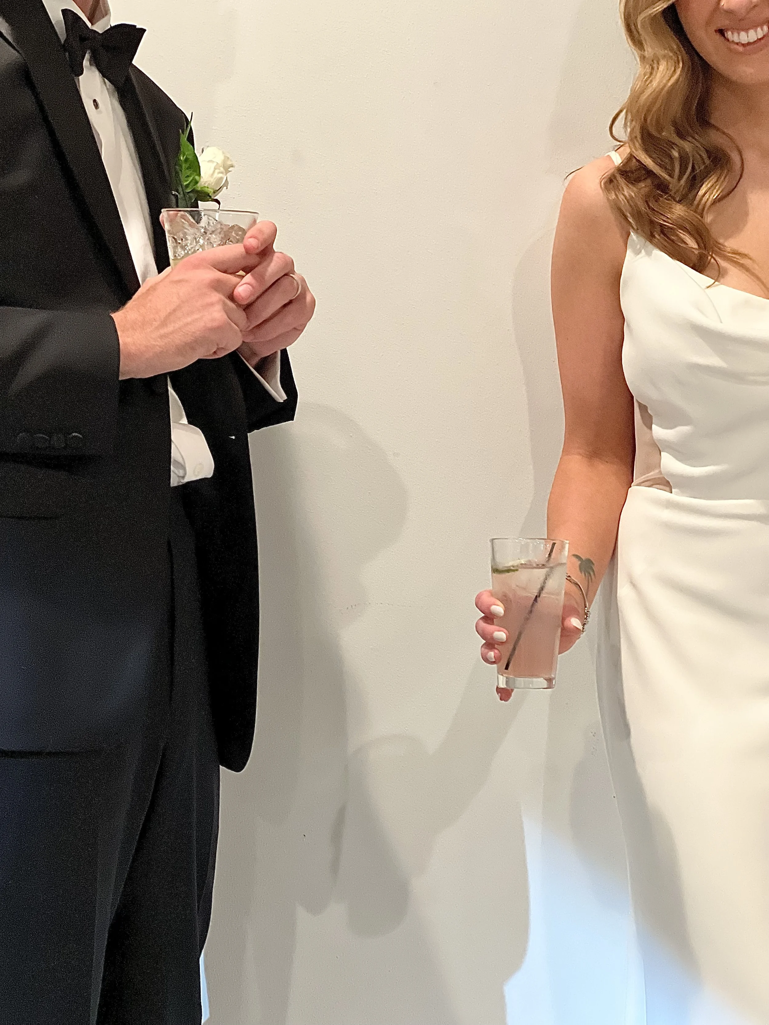 Man and woman dressed in formal attire holding drinks at a celebration or event.