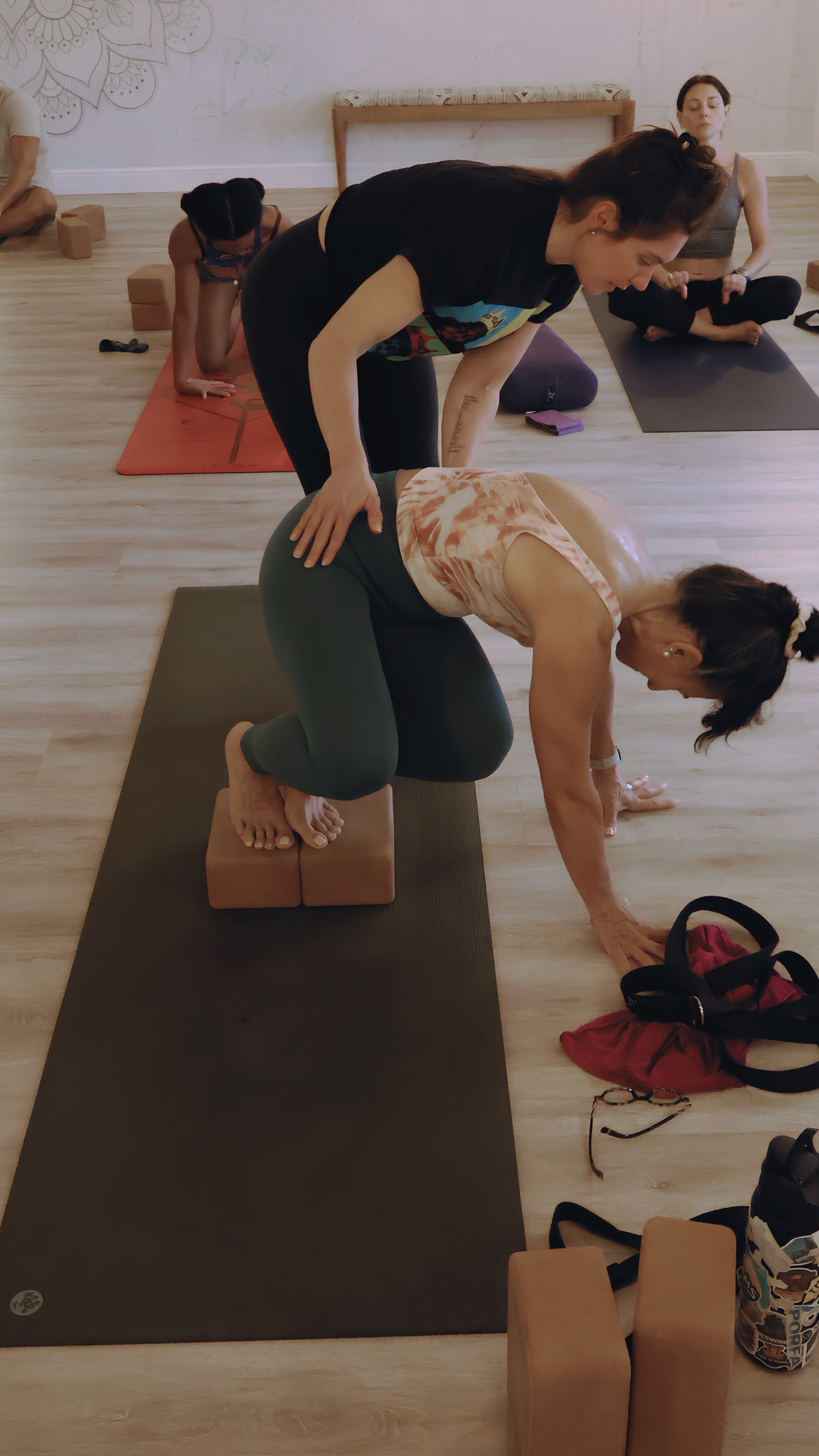 Brittney Coates Yoga YogaUX, user-friendly yoga for your inner space. practicing yoga in a yoga studio, performing a backbend pose with her hands and feet on the floor, her body arched over yoga blocks. She is wearing a
