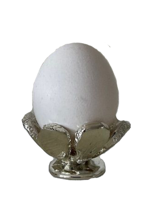 A white egg resting on a silver foil holder.