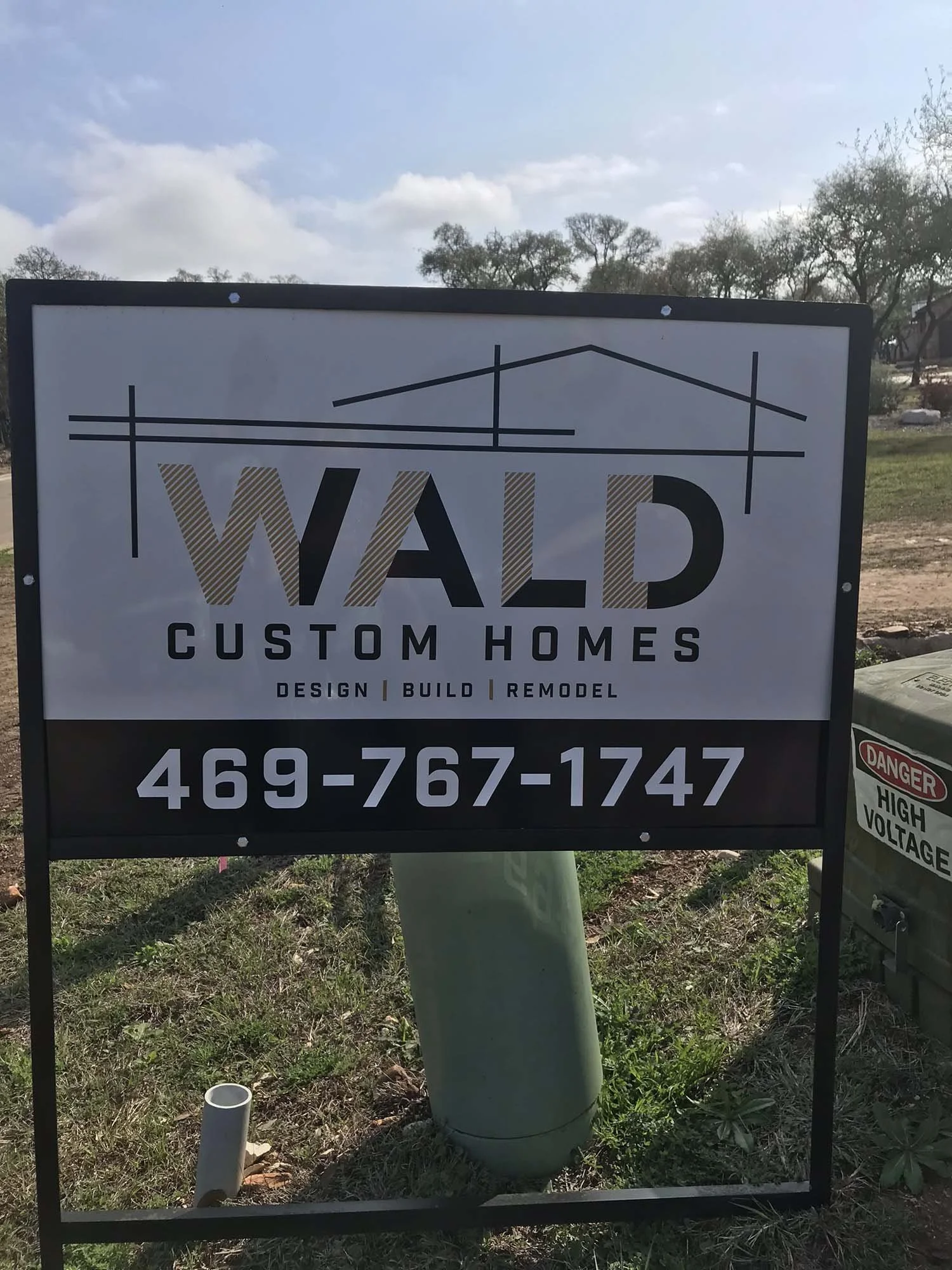 Sign for Wald Custom Homes with contact number 469-767-1747, featuring a design of house outlines.
