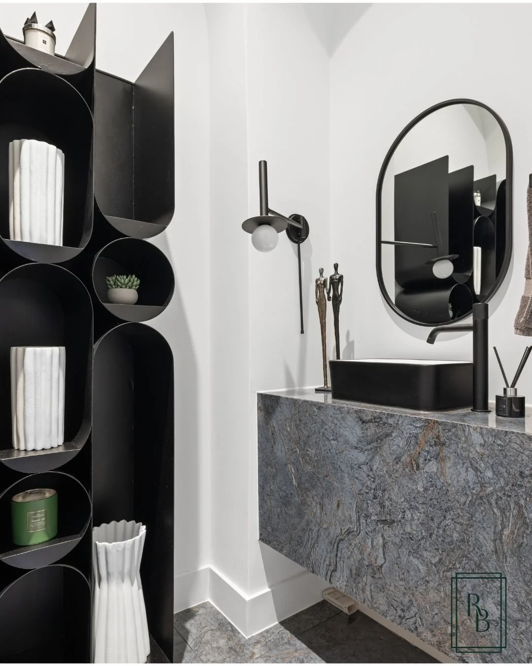 A study in shapes. I introduced a distinctive display element within the inset wall of this powder bathroom. It echoes the mirror&rsquo;s oval form while also reflecting the round bulbs in the wall sconces and the artwork across the room&mdash;though