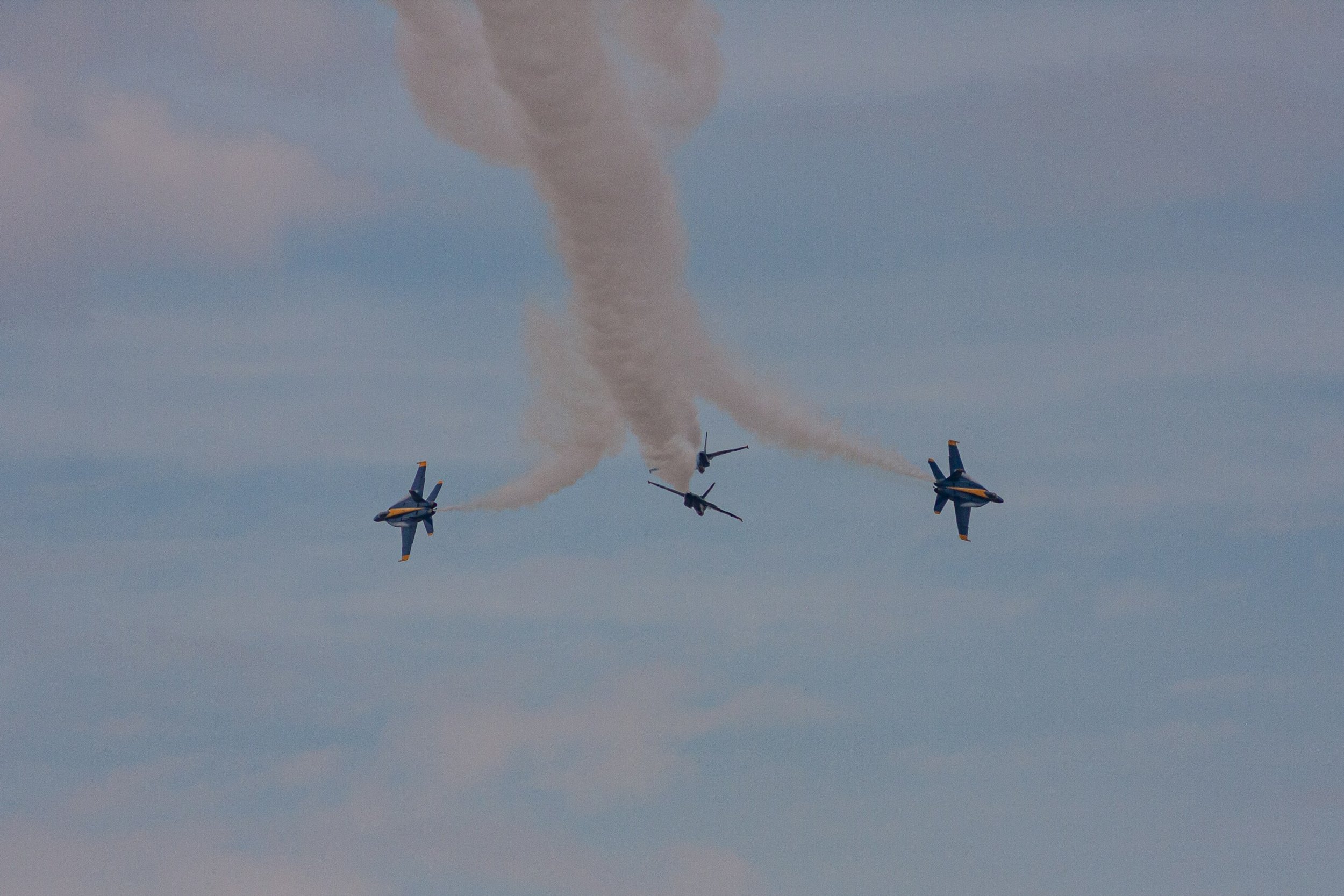 Three aircraft separate beneath curling smoke trails.