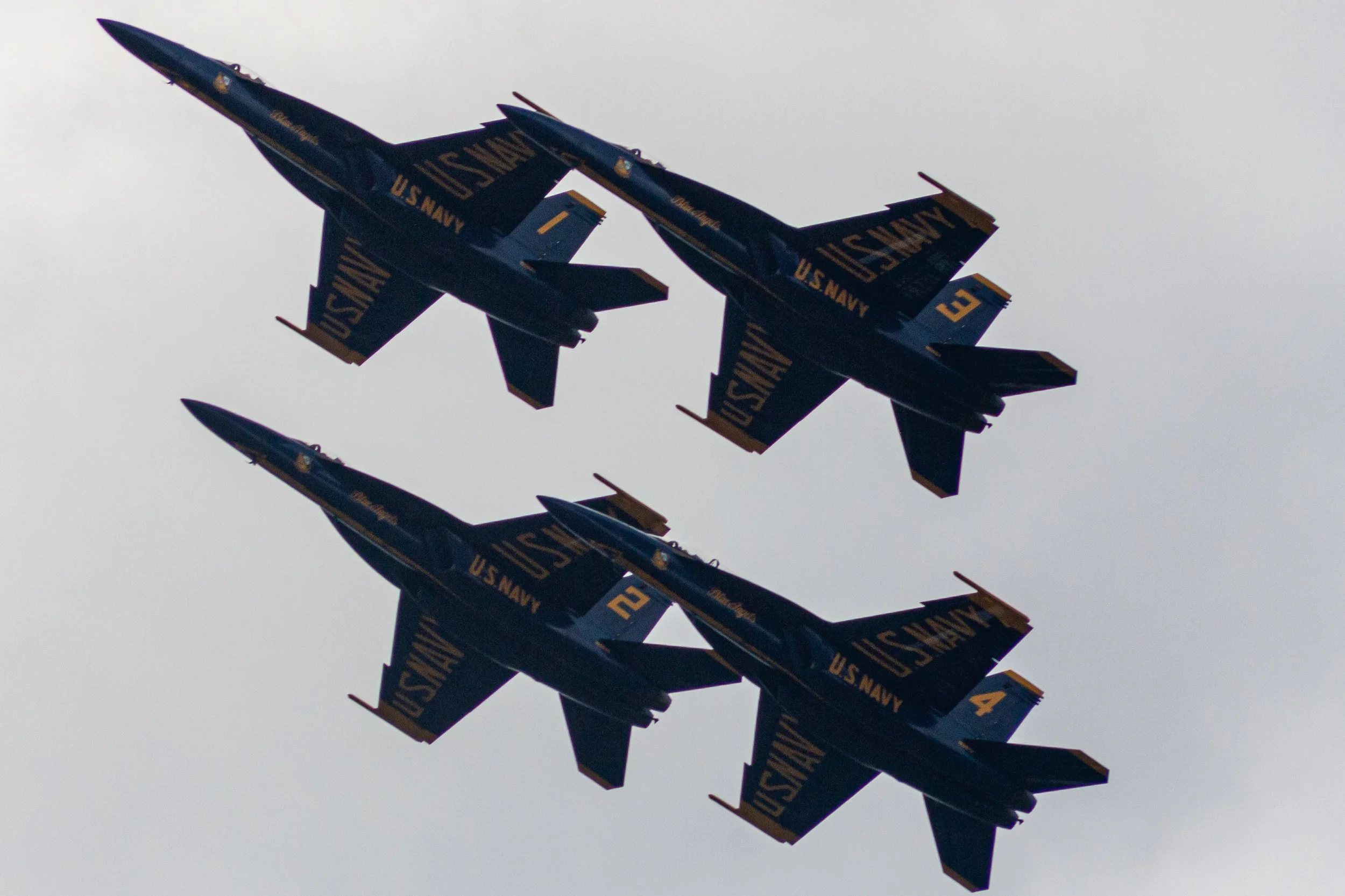 Four Blue Angels aircraft fly in close formation.