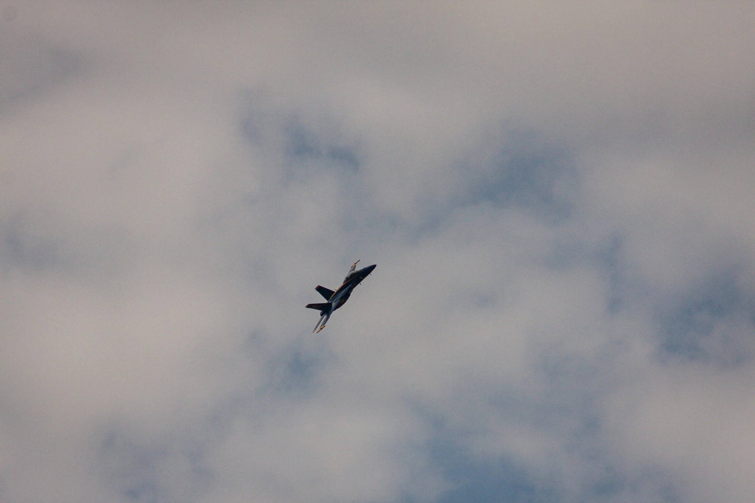 A single jet banks beneath softly lit clouds.
