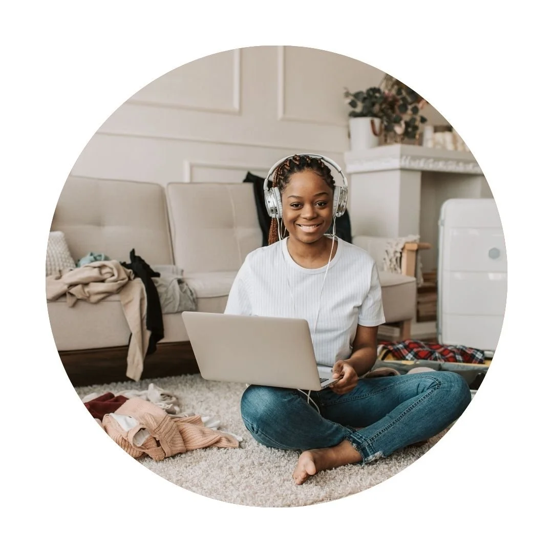 Woman sitting on the floor with headphones and a laptop, representing the Career/Life Redesign Intensive in Dallas, TX.