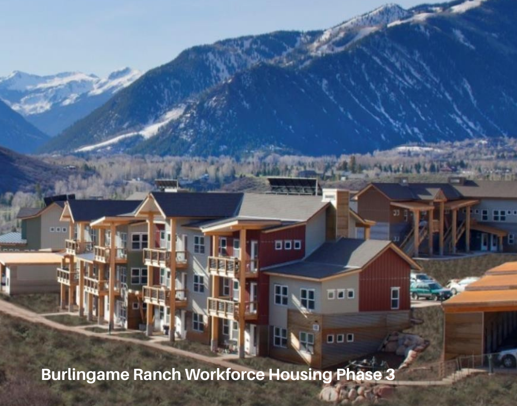 Multi-story residential buildings with mountain range in the background at Burlingame Ranch Workforce Housing Phase 3.