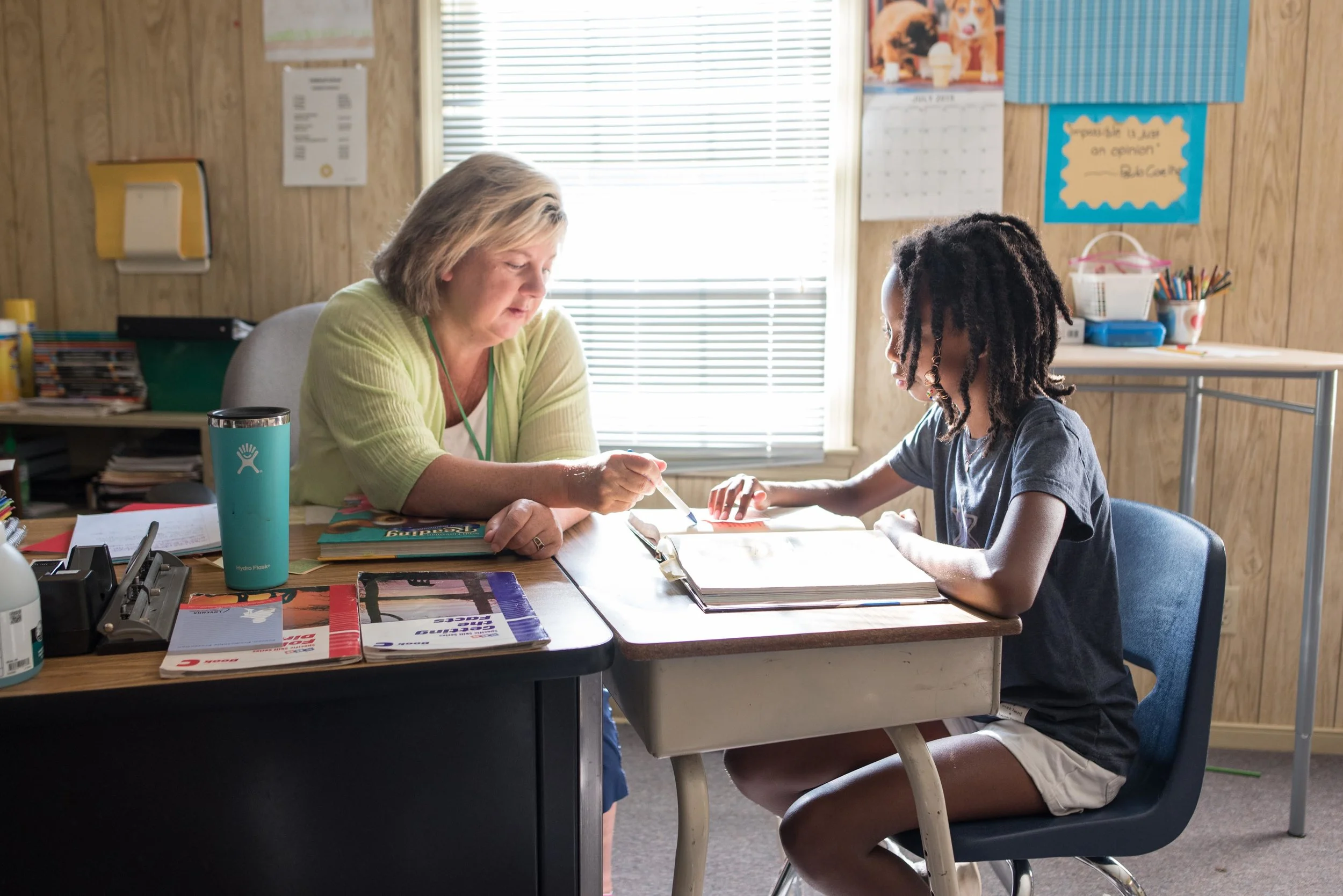 A teacher helps a student with specialized reading techniques during summer camp classes.
