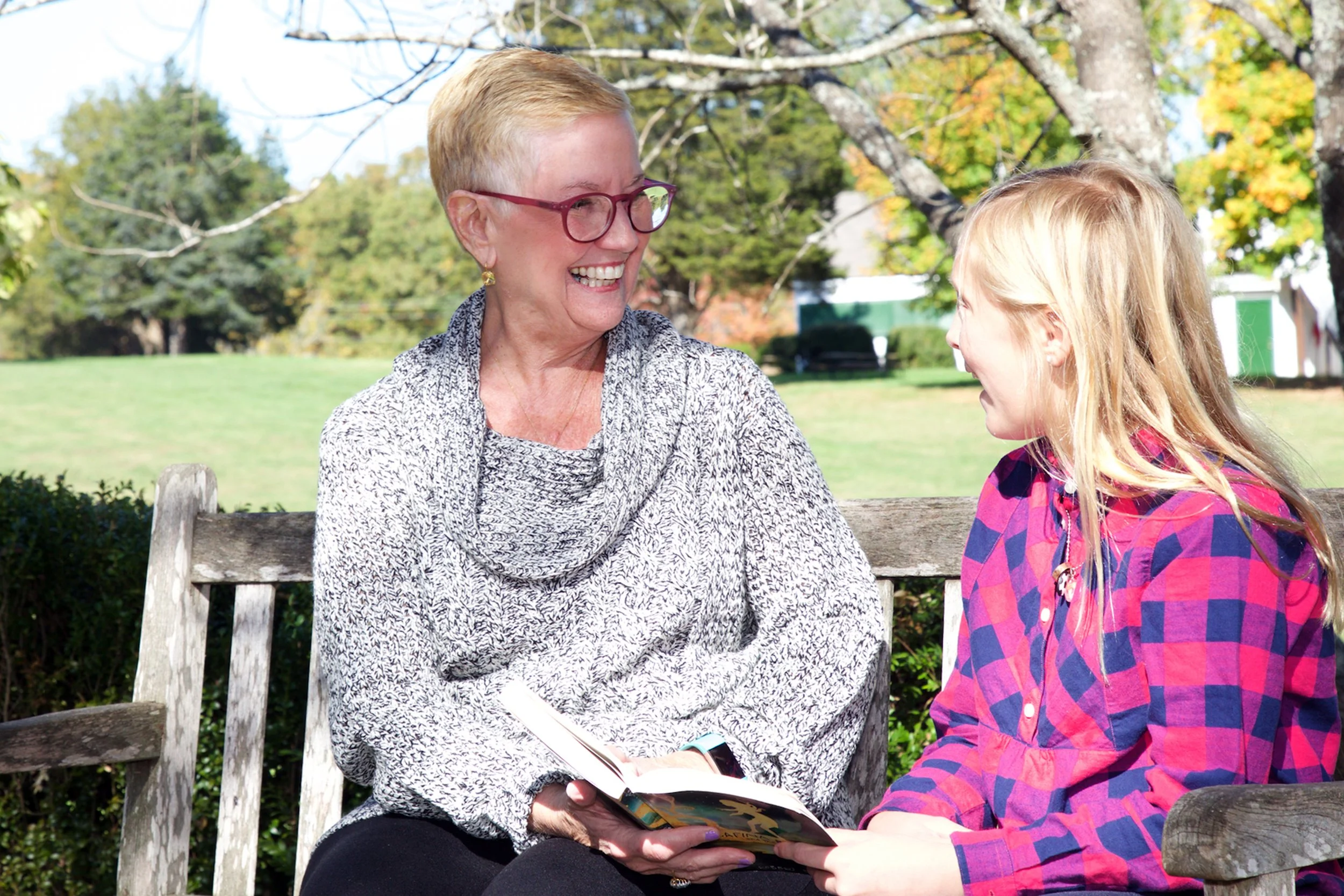 Oakland School teacher and student on bench with book