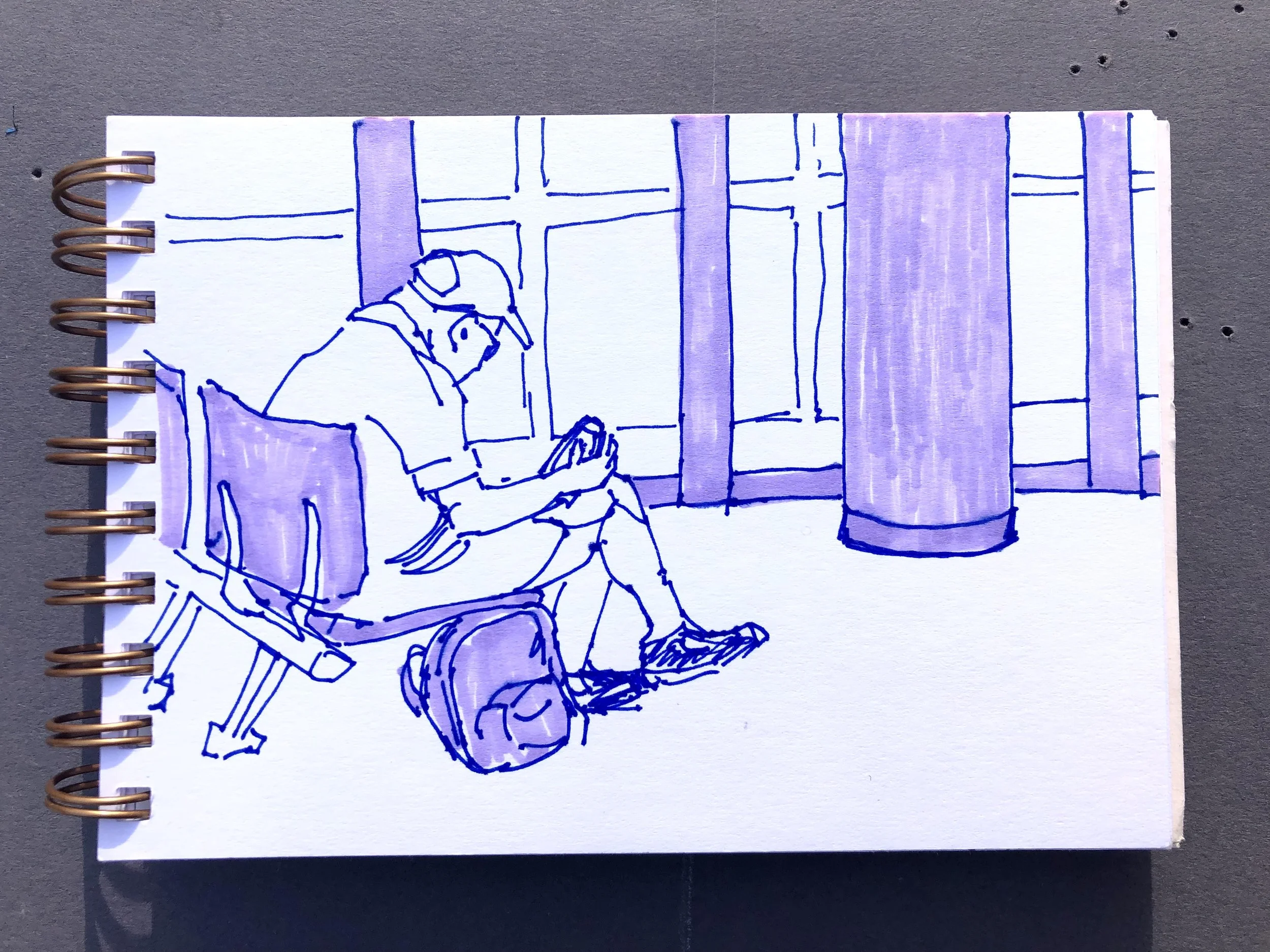 Sketch of a person sitting on a bench, looking at a mobile phone, with a backpack on the ground beside them, in front of large windows with curtains.