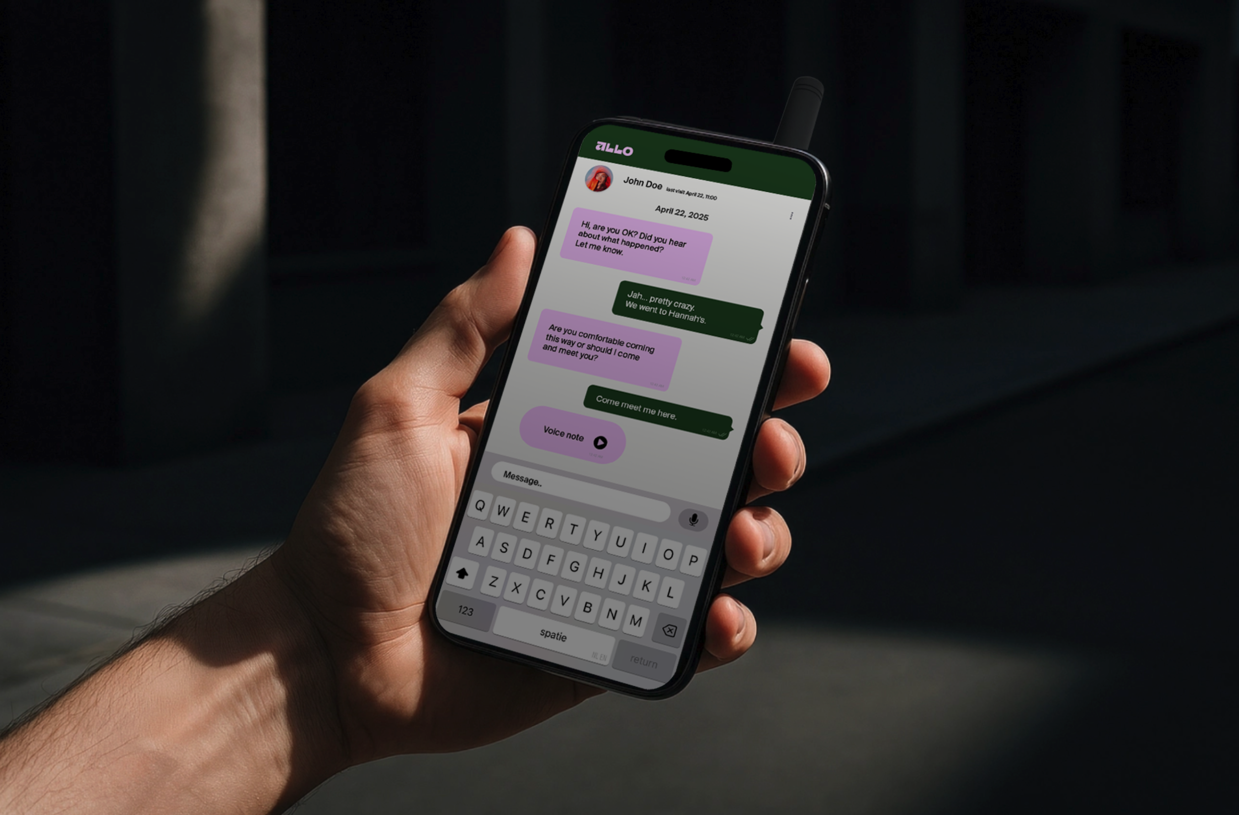 A person holding a smartphone displaying a text message conversation with a green and purple theme on the screen.