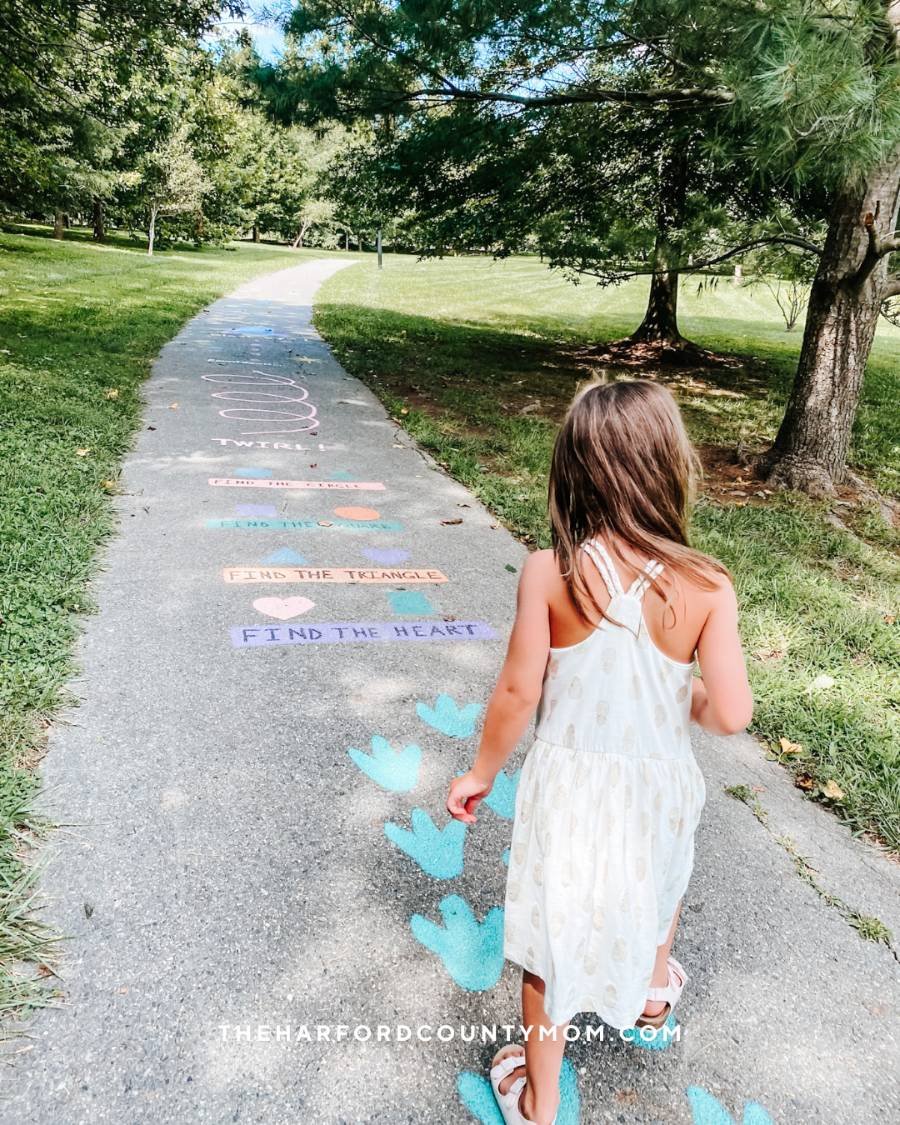 Girl walks along painted activities on Abingdon Library Sensory Trail in Abingdon, Maryland. The perfect outdoor activity to tag on to a visit to the Abingdon Public Library
