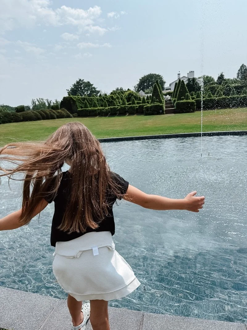girl running along the edge of the pool at ladew gardens in harford county maryland